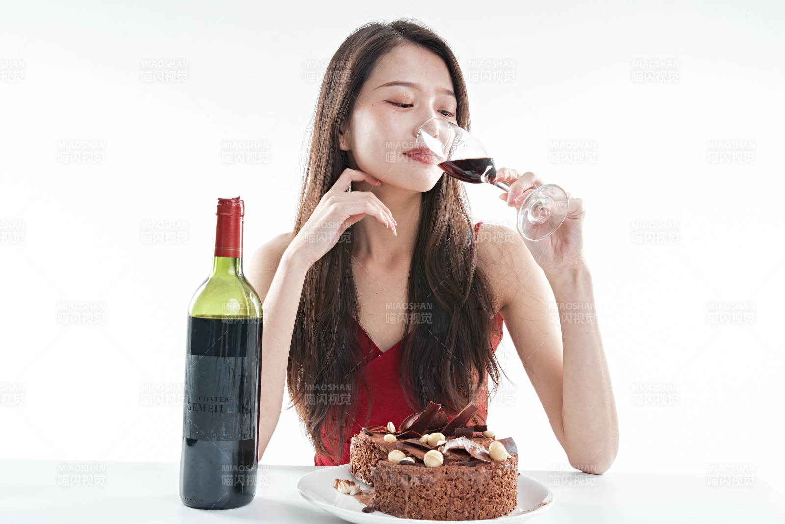 喝红酒品尝蛋糕的年轻女性图片