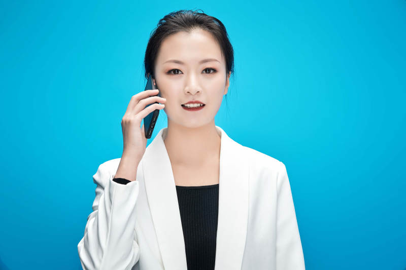 身穿西服拿着手机与文件夹的亚洲商务女士