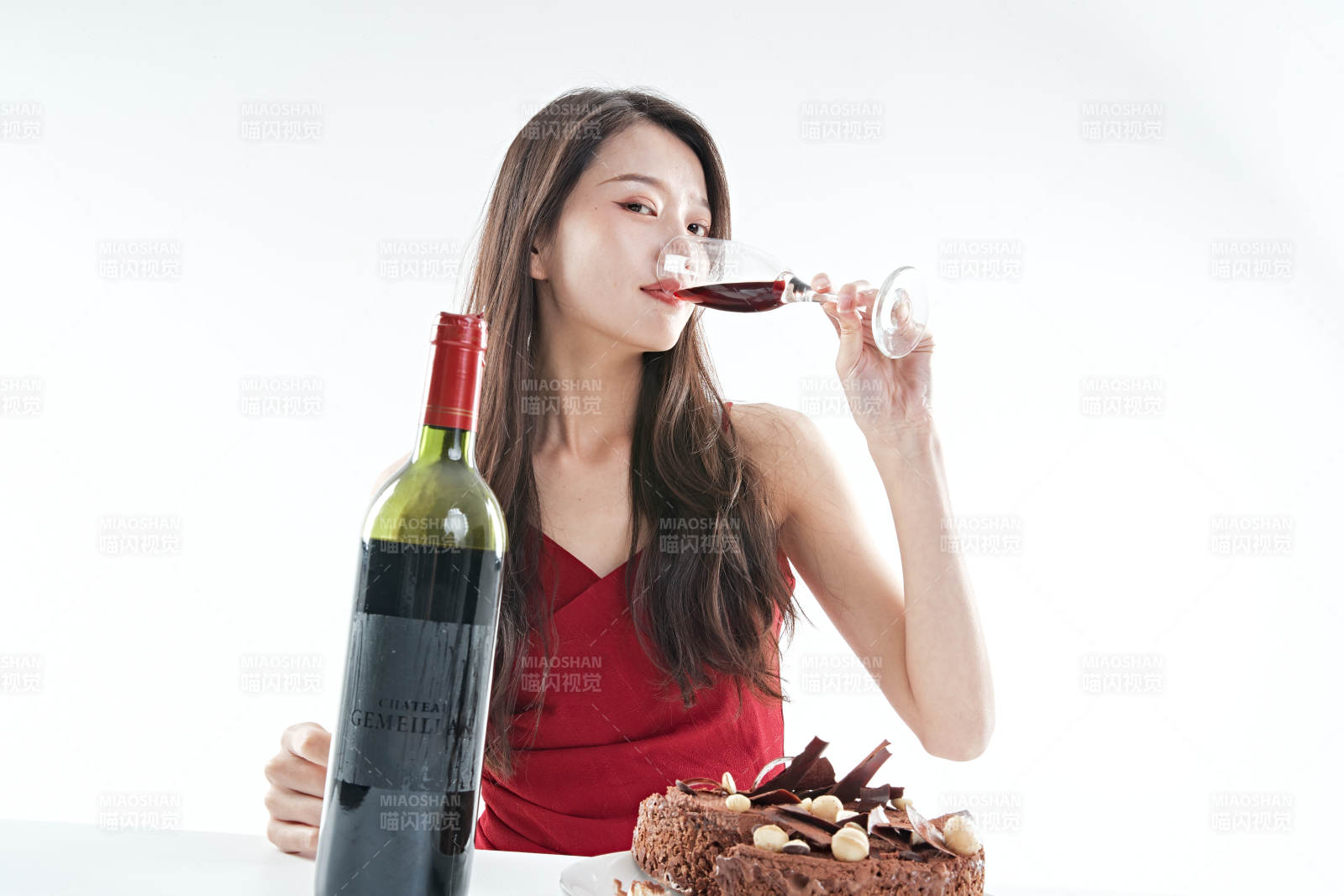 喝紅酒品嘗蛋糕的年輕女性