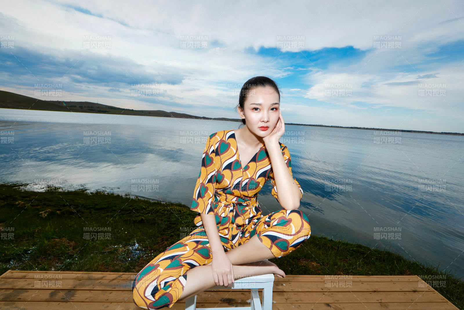 悠闲的坐在美丽湖岸码头的亚洲年轻女性人像