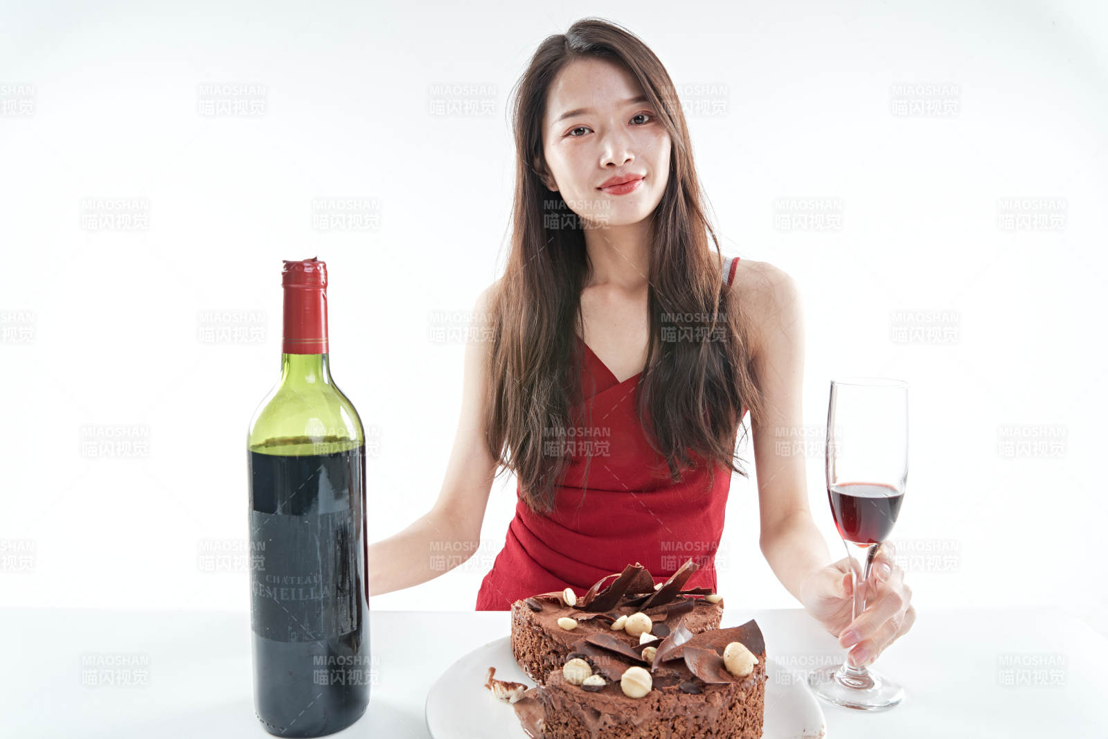 喝红酒品尝蛋糕的年轻女性