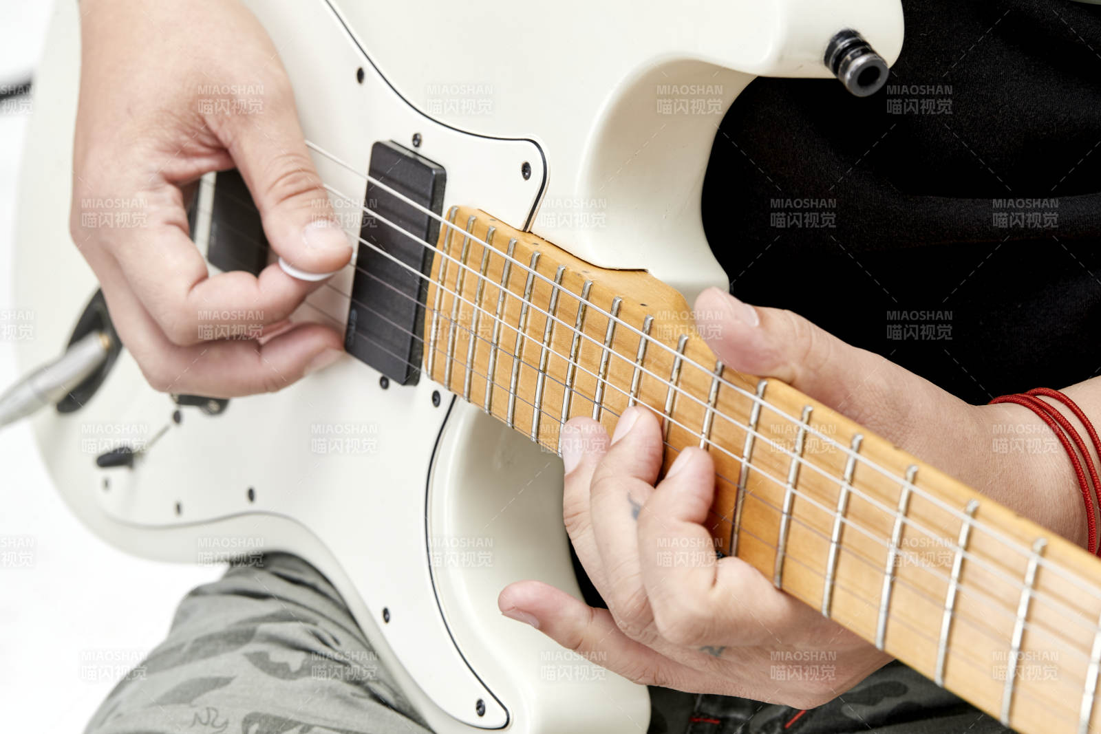 示范演奏搖滾電吉他的亞洲男性樂手人像局部特寫