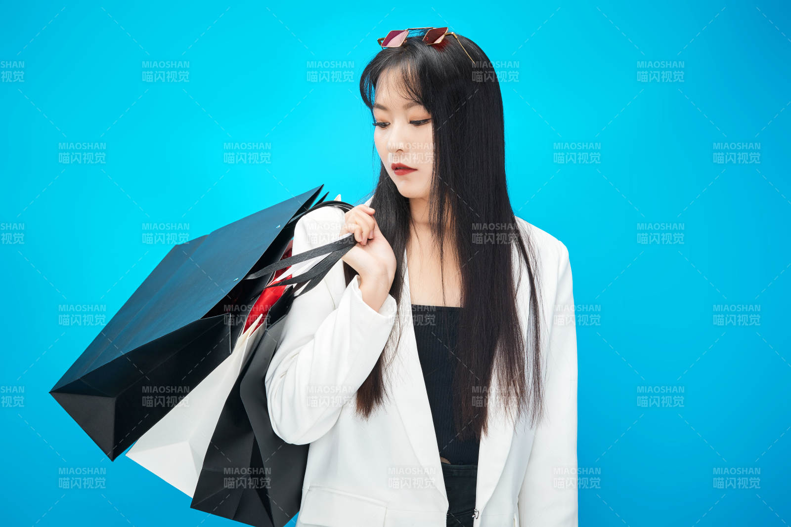 青蓝色背景下手提购物袋的亚洲时尚少女