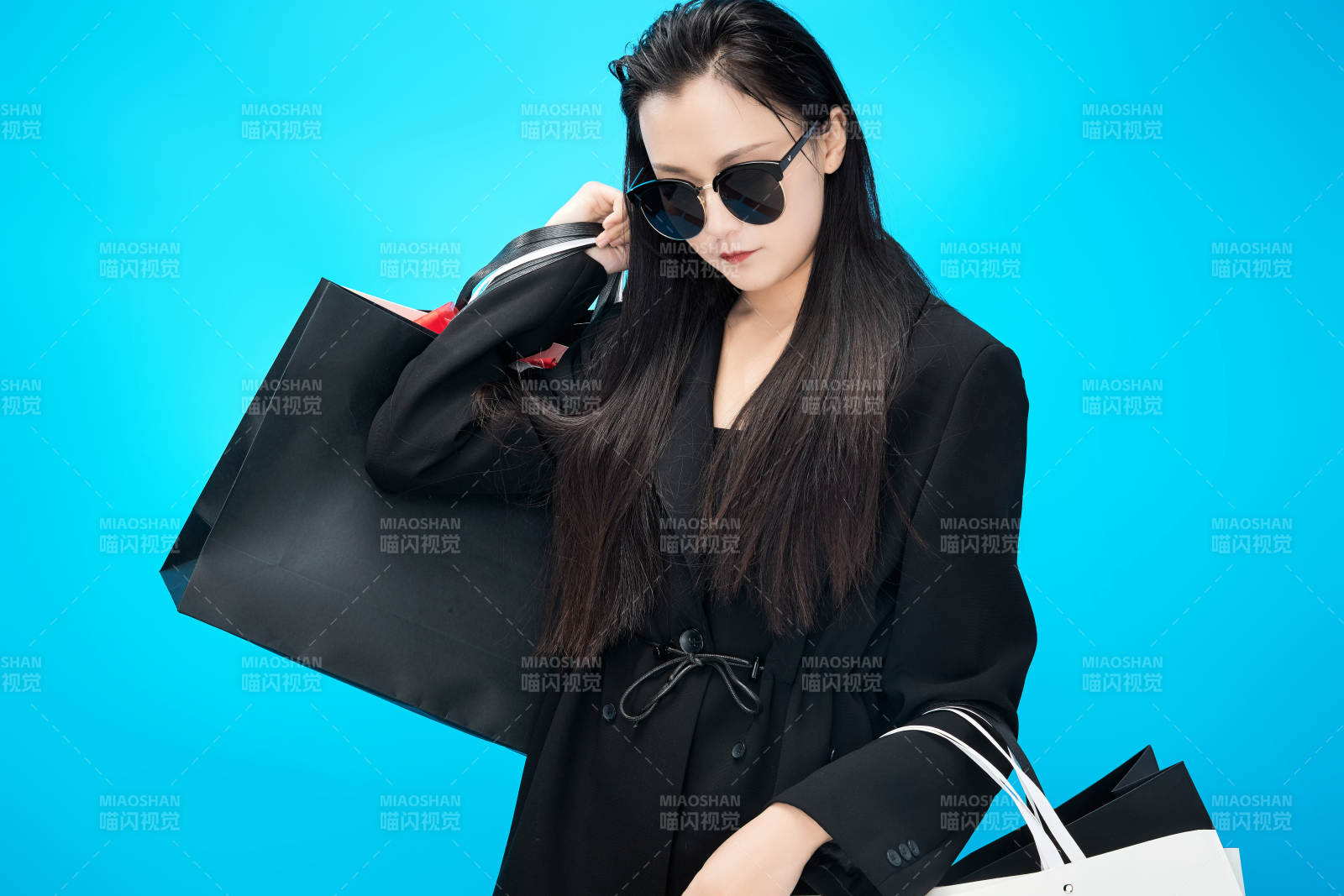 青蓝色背景下手提购物袋的亚洲时尚少女