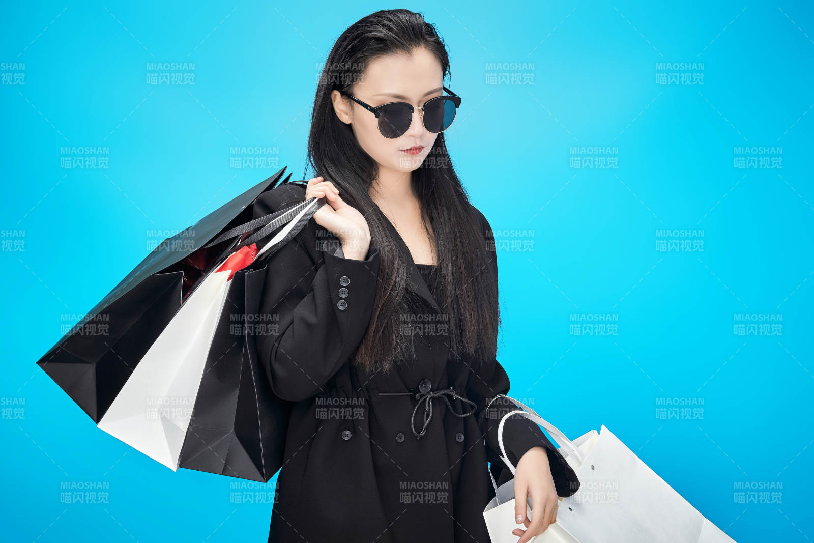 青蓝色背景下手提购物袋的亚洲时尚少女