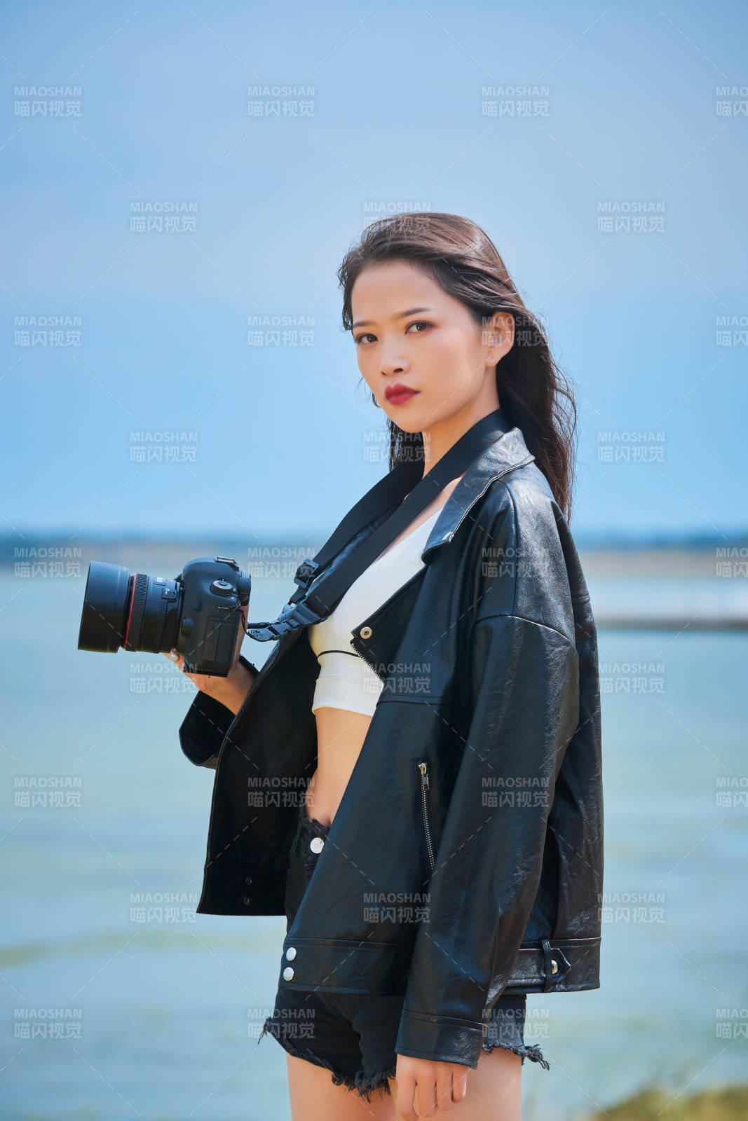 户外湖畔进行拍摄的亚洲青年女性摄影师图片