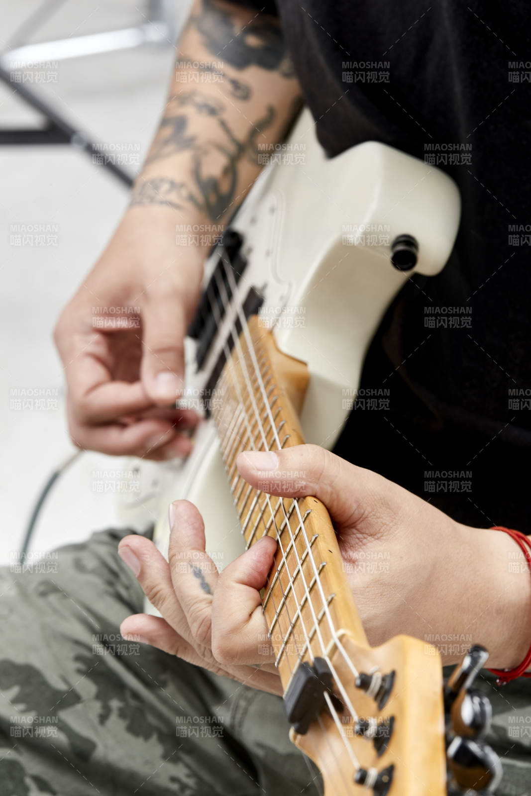 示范演奏摇滚电吉他的亚洲男性乐手人像局部特写