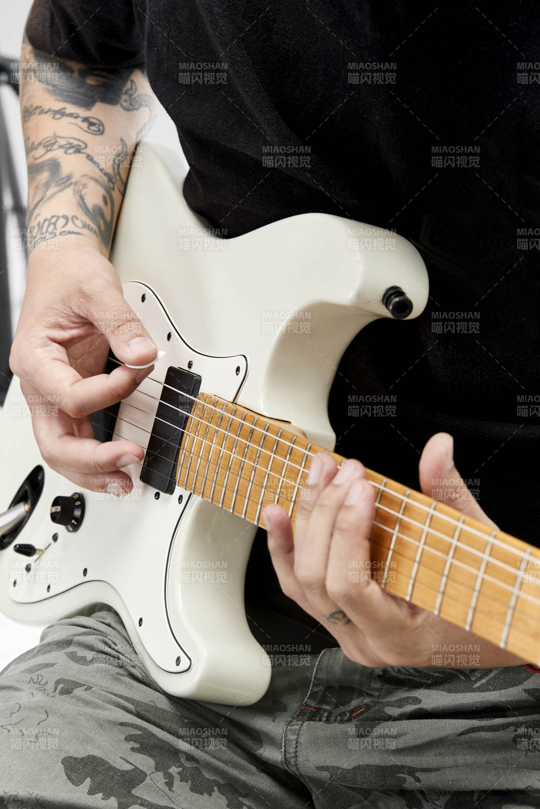 示范演奏搖滾電吉他的亞洲男性樂手人像局部特寫