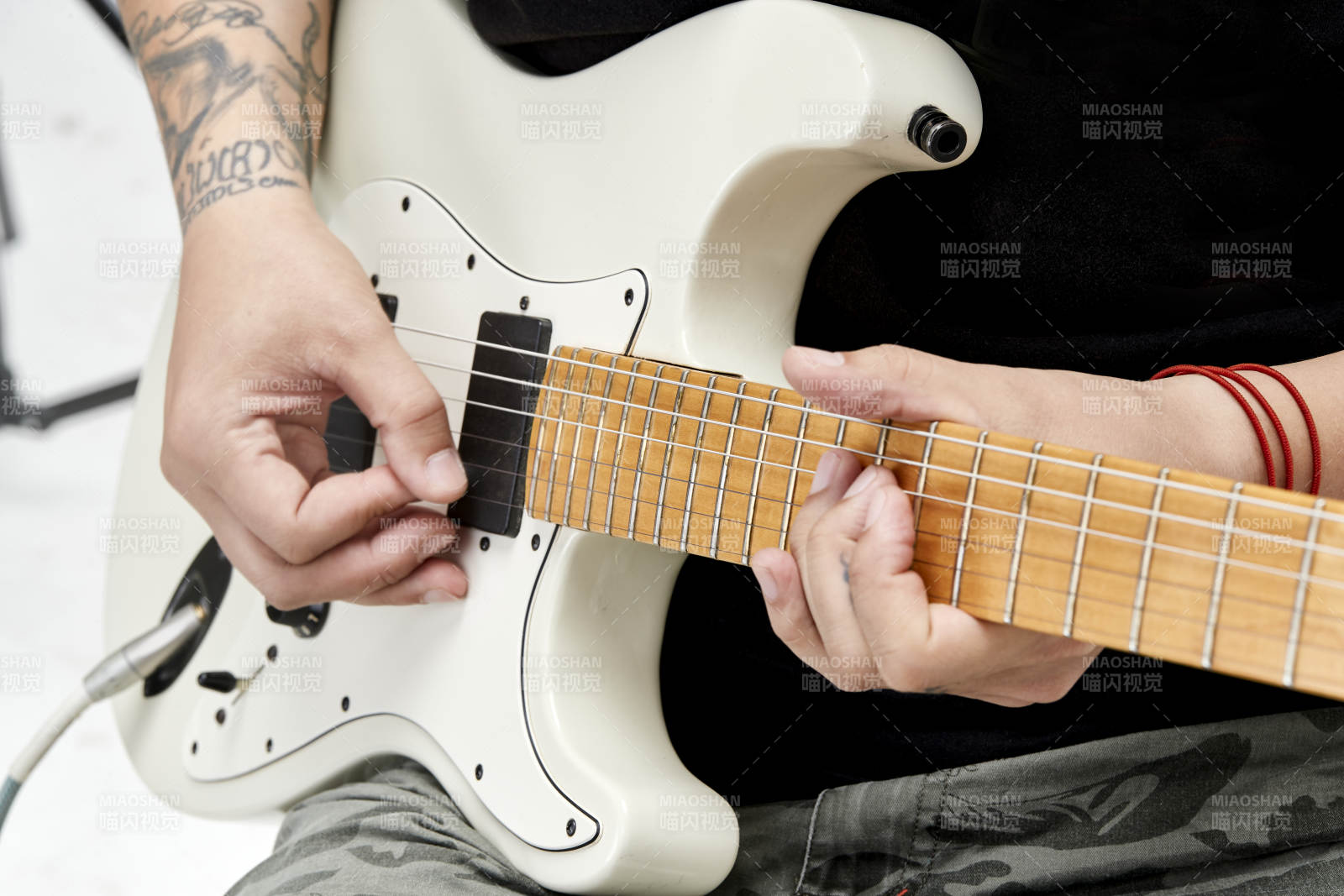 示范演奏搖滾電吉他的亞洲男性樂手人像局部特寫