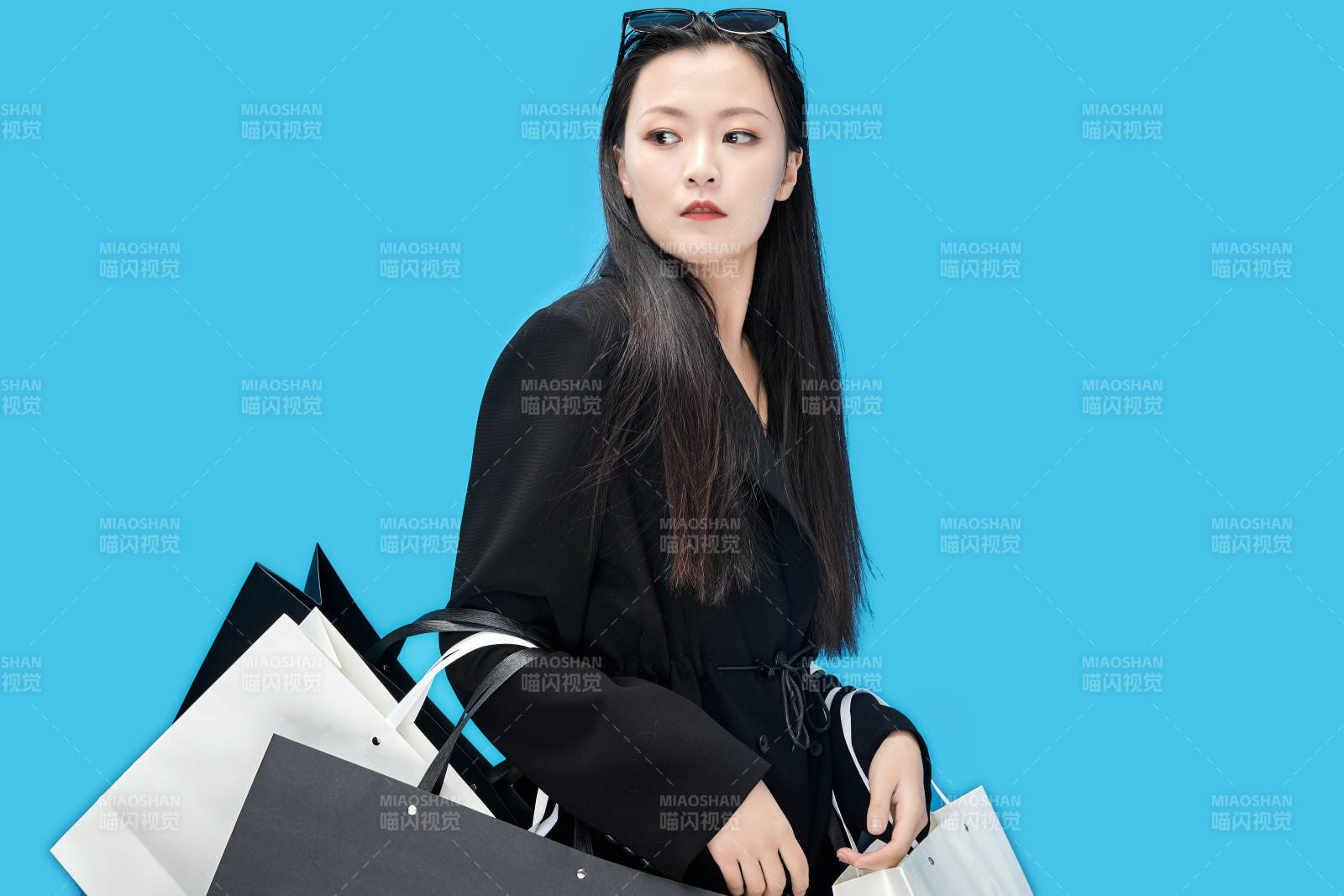 青藍色背景下手提購物袋的亞洲時尚少女