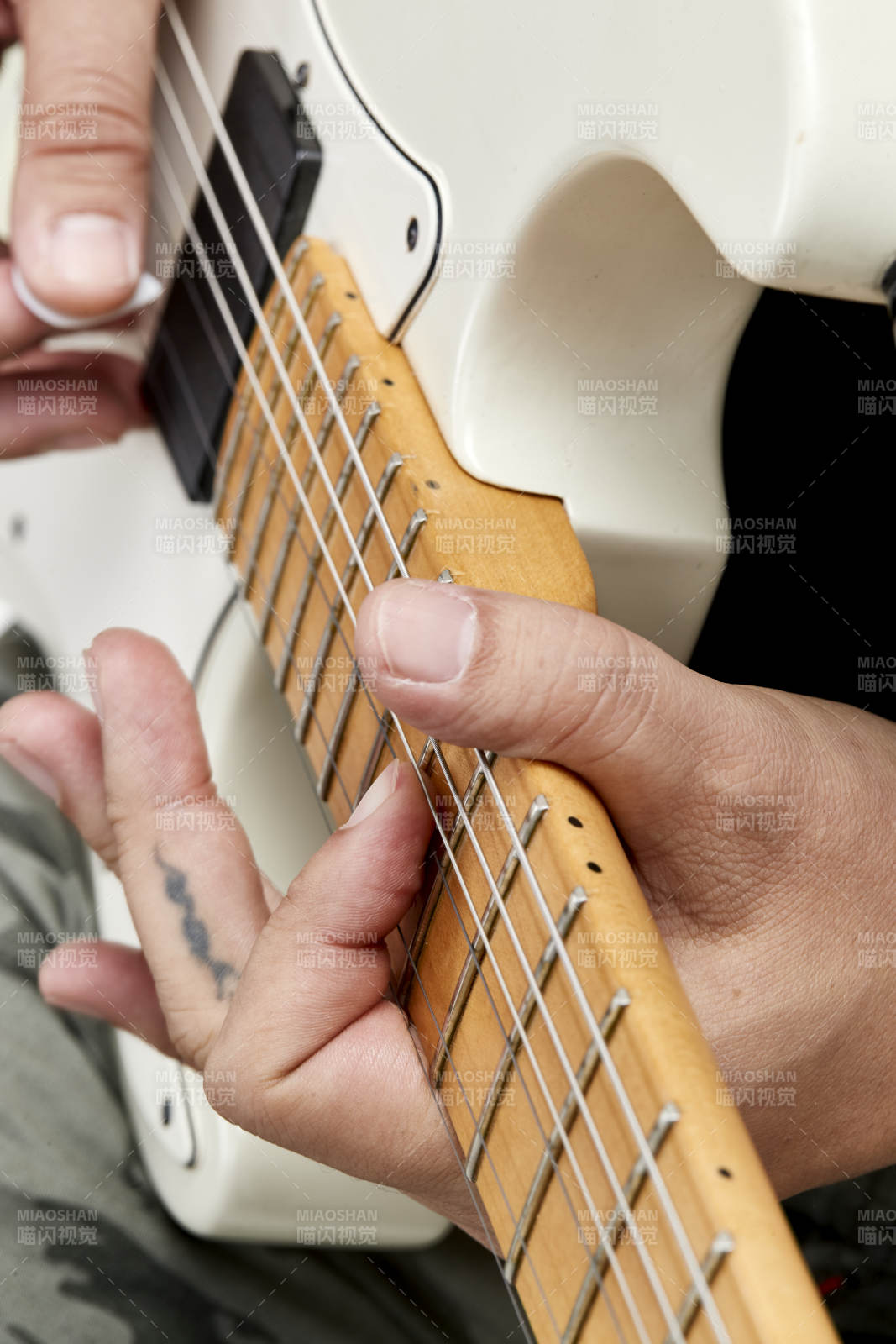 示范演奏搖滾電吉他的亞洲男性樂手人像局部特寫