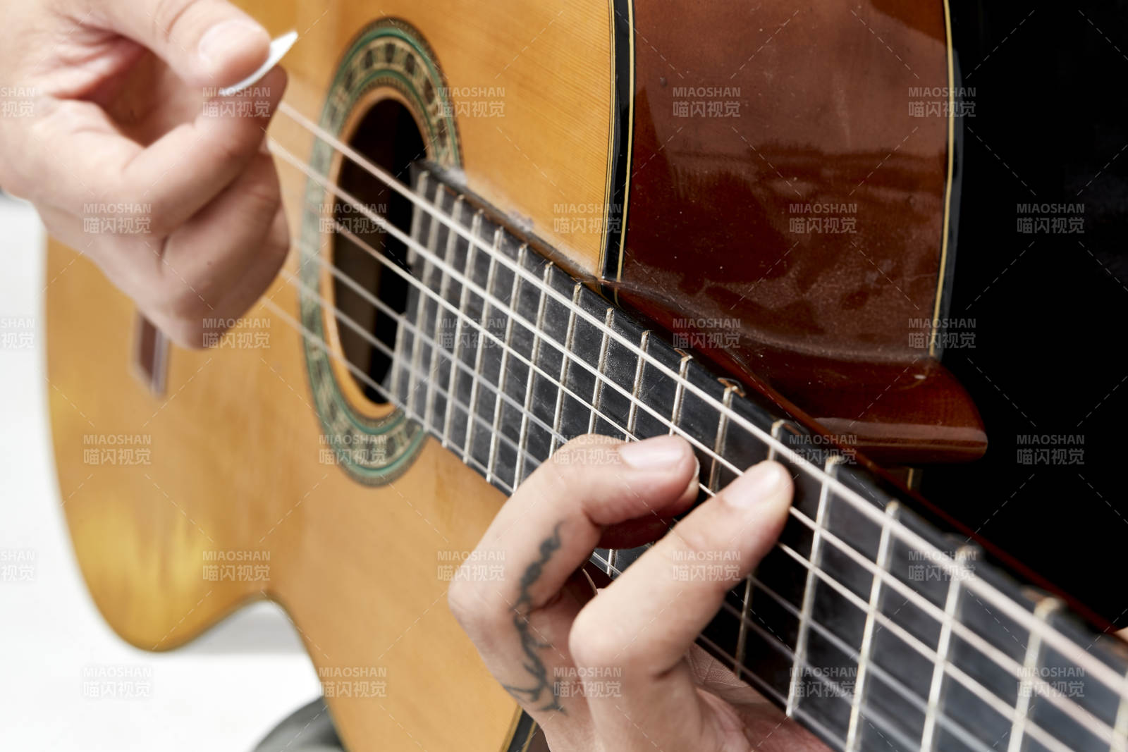 示范演奏古典吉他的亞洲男性樂手人像局部特寫