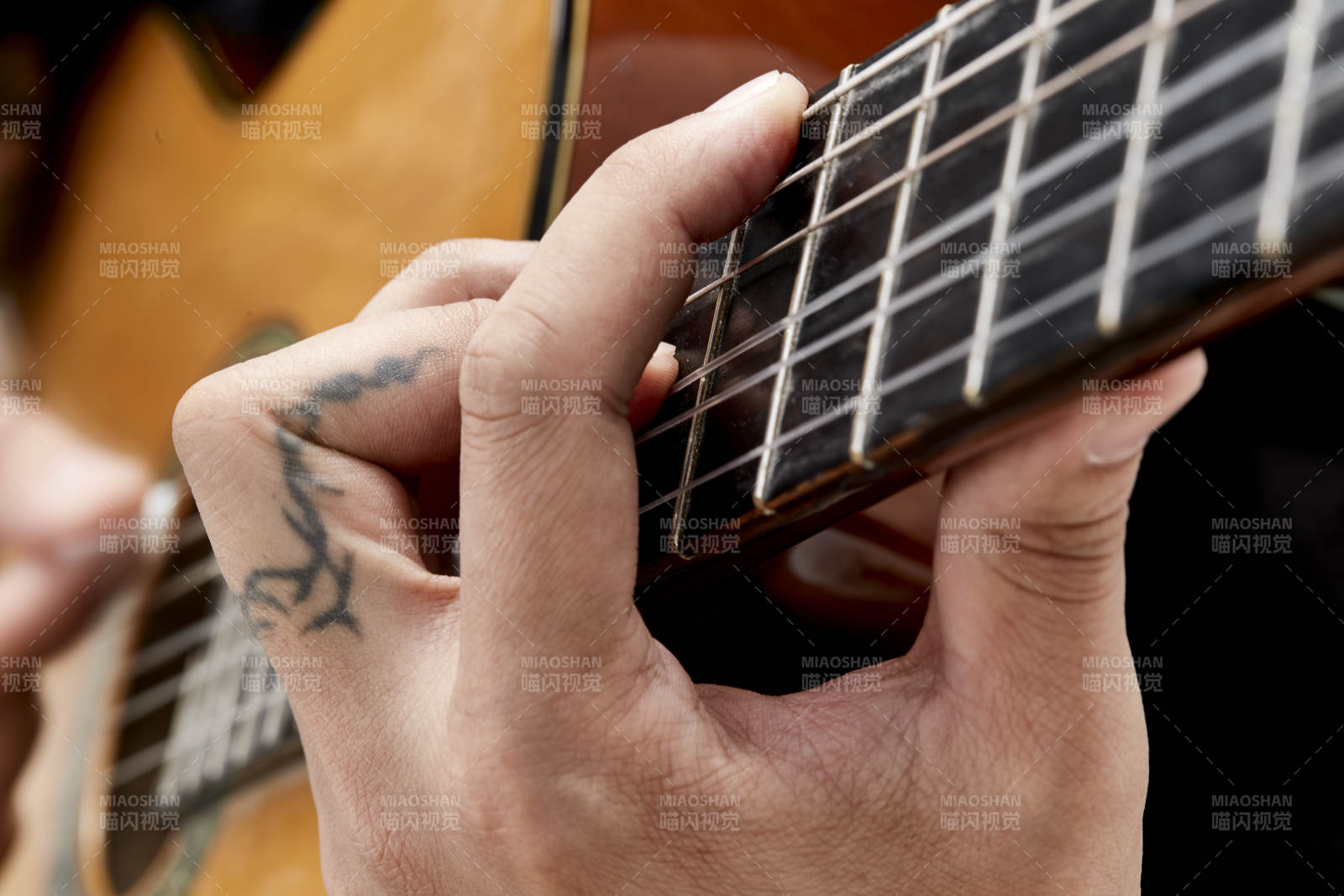 示范演奏古典吉他的亞洲男性樂手人像局部特寫