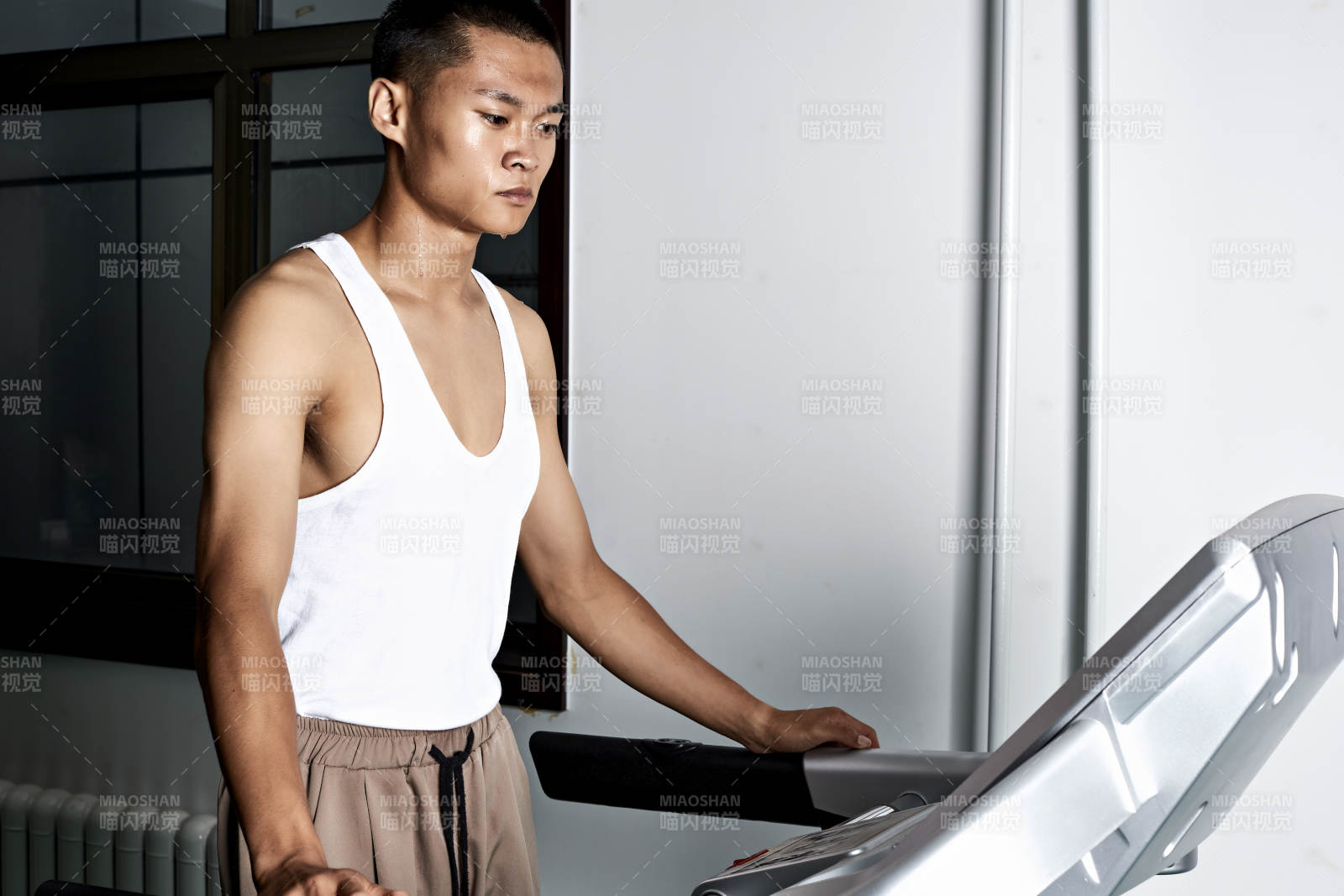 在室內用跑步機進行鍛煉的亞洲健身男士形象