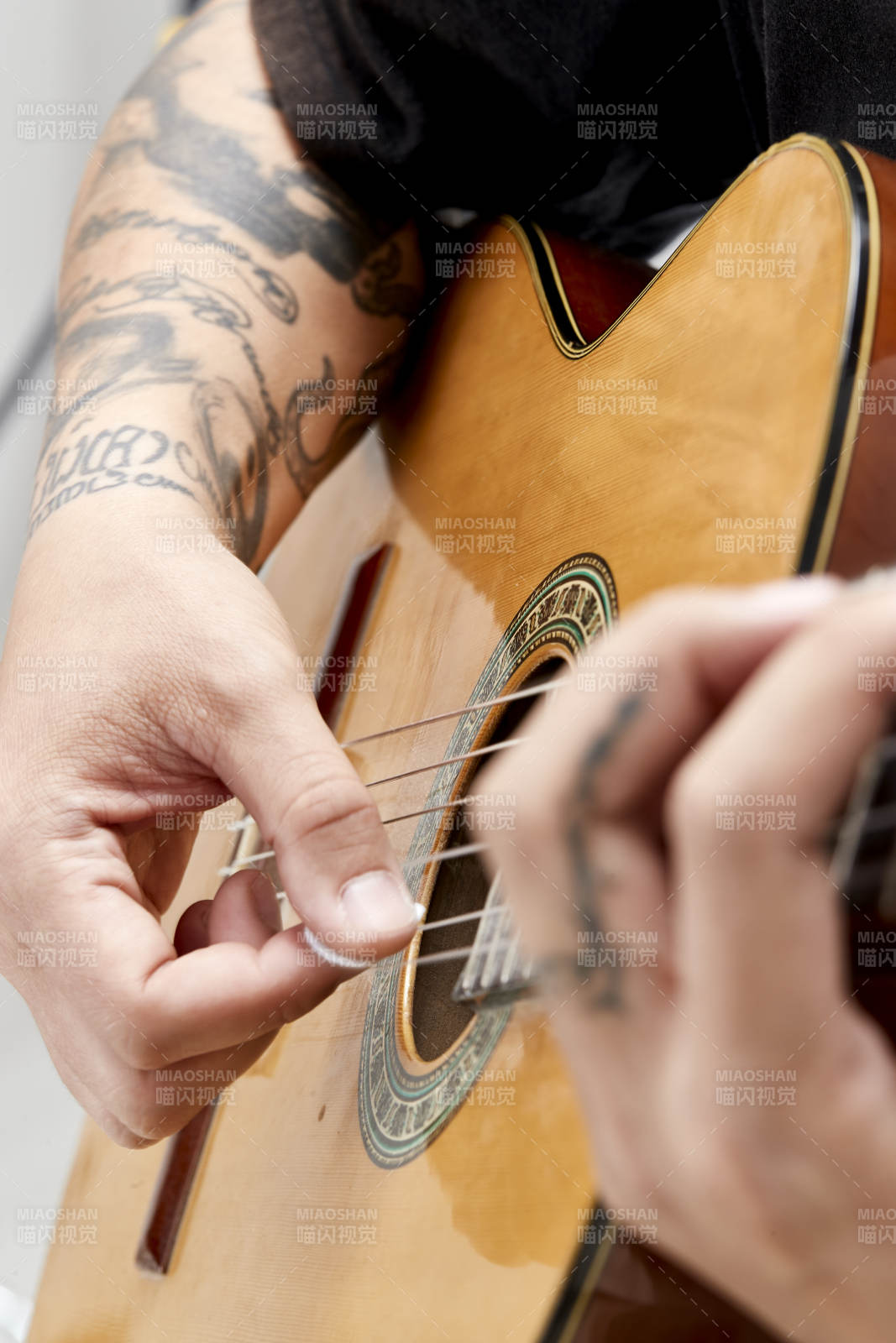 示范演奏古典吉他的亞洲男性樂手人像局部特寫