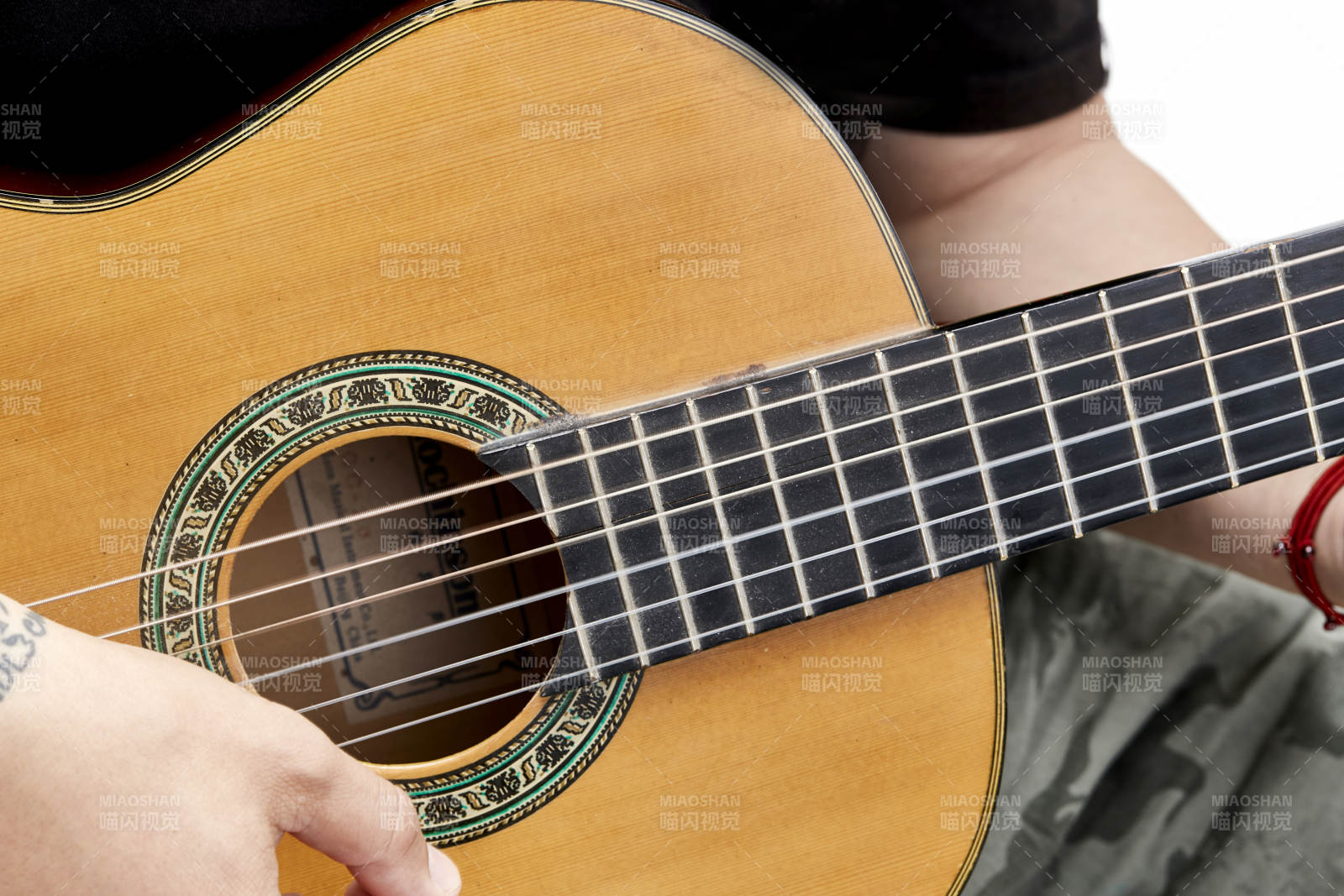 示范演奏古典吉他的亞洲男性樂手人像局部特寫