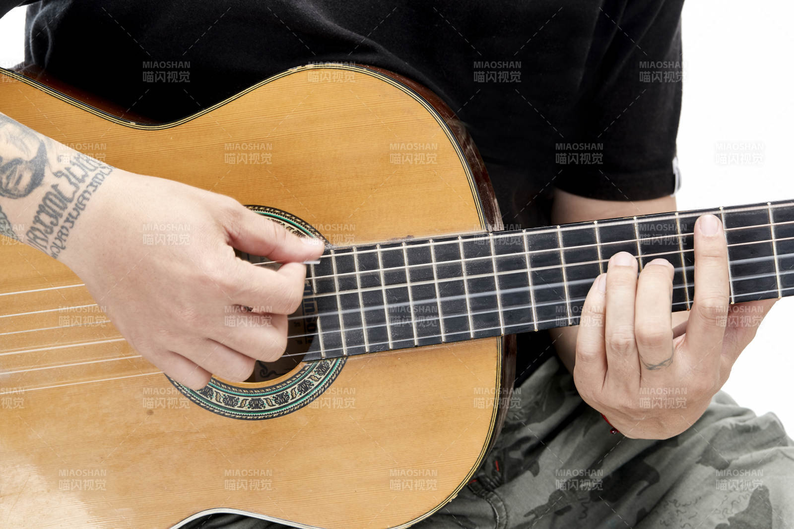 示范演奏古典吉他的亞洲男性樂手人像局部特寫