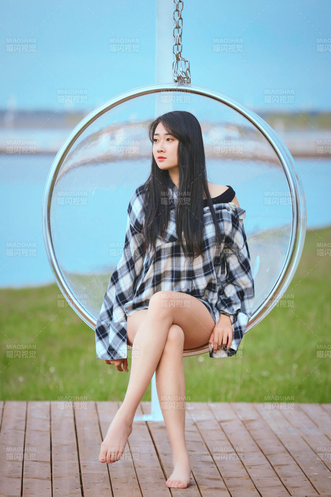 草原湖畔坐在透明秋千里的亞洲年輕女性人像