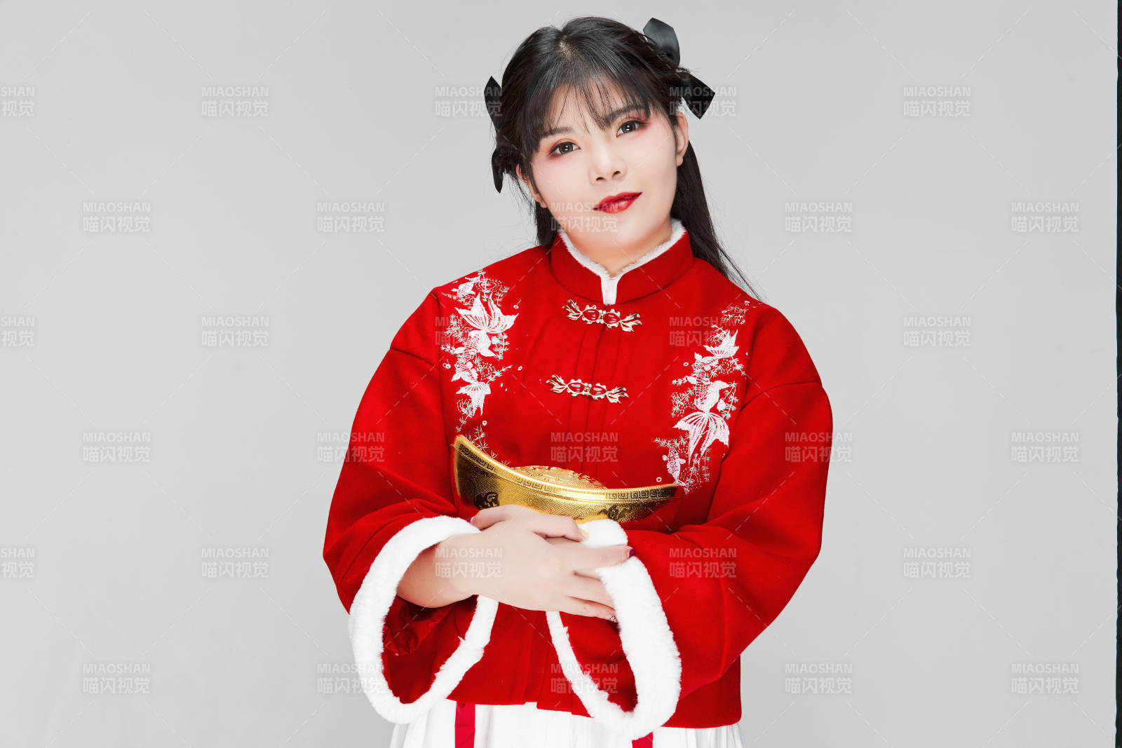 手捧金元寶身穿喜慶漢服的可愛少女