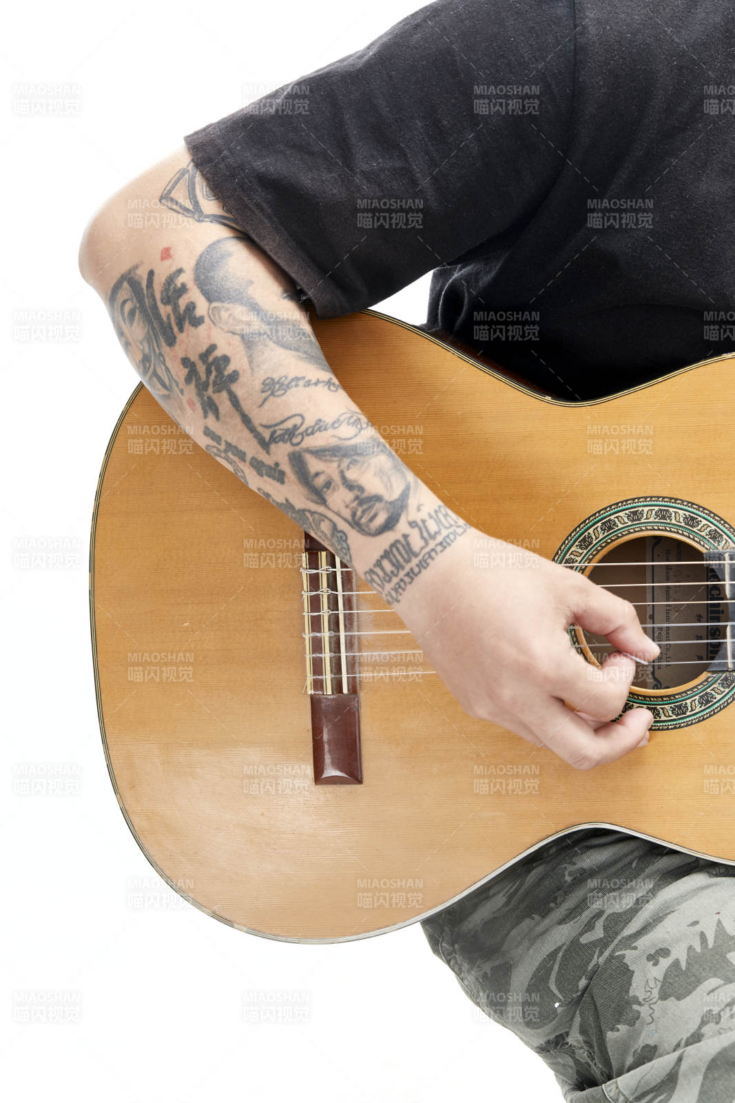 示范演奏古典吉他的亞洲男性樂手人像局部特寫