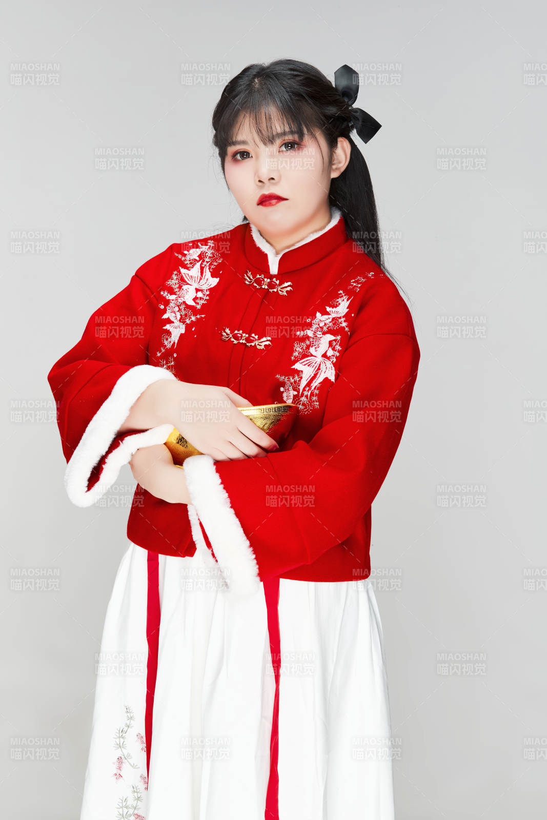 手捧金元寶身穿喜慶漢服的可愛少女