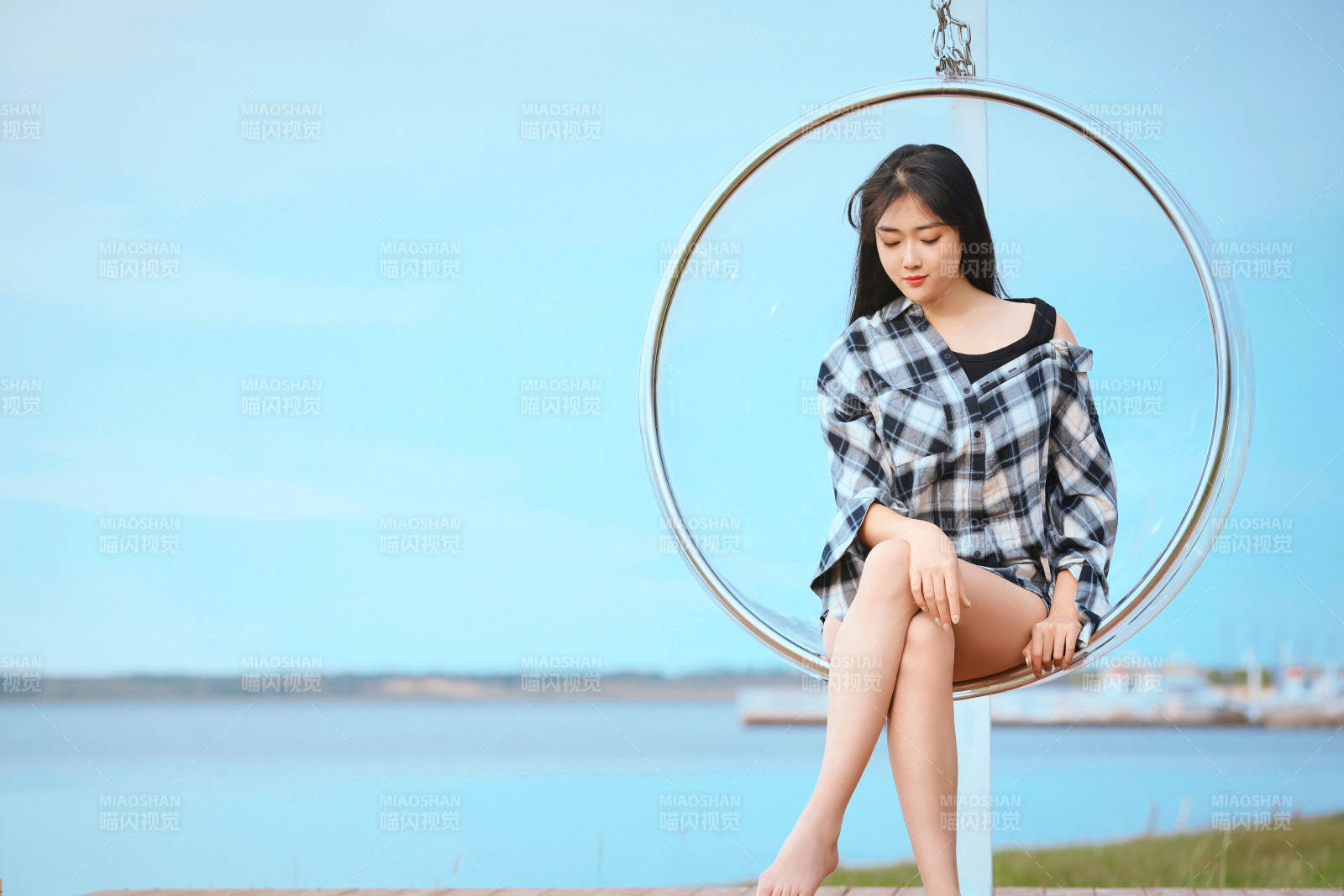 草原湖畔坐在透明秋千里的亞洲年輕女性人像