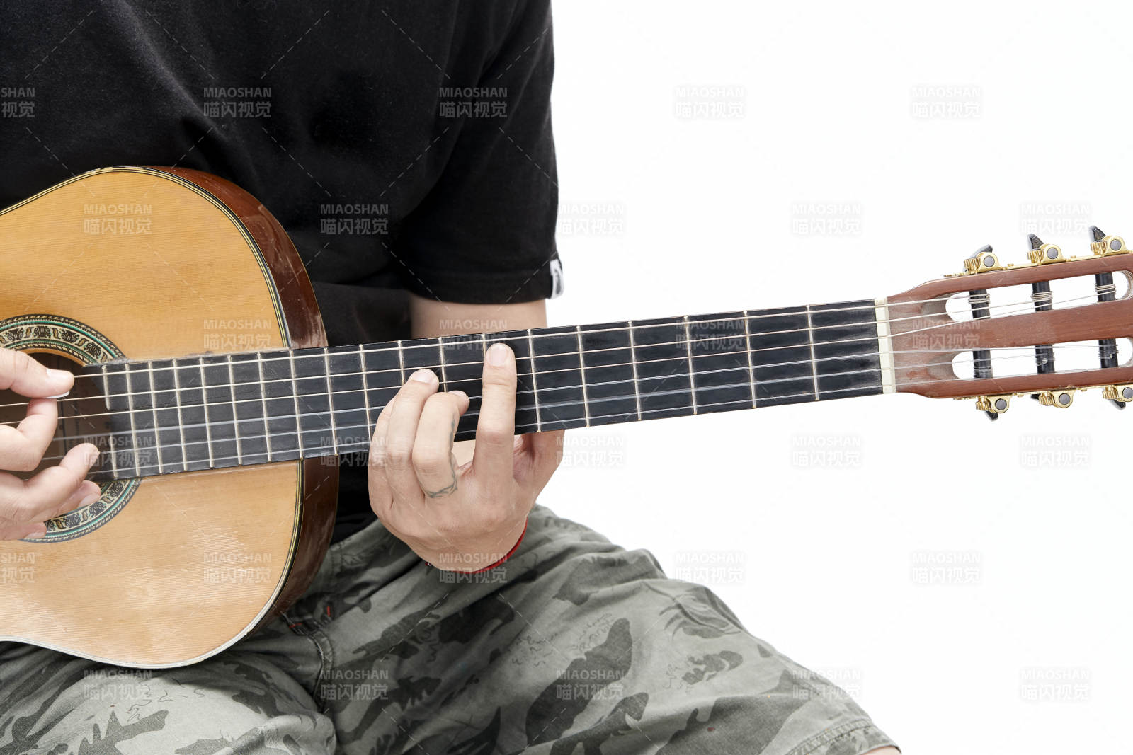 示范演奏古典吉他的亞洲男性樂手人像局部特寫