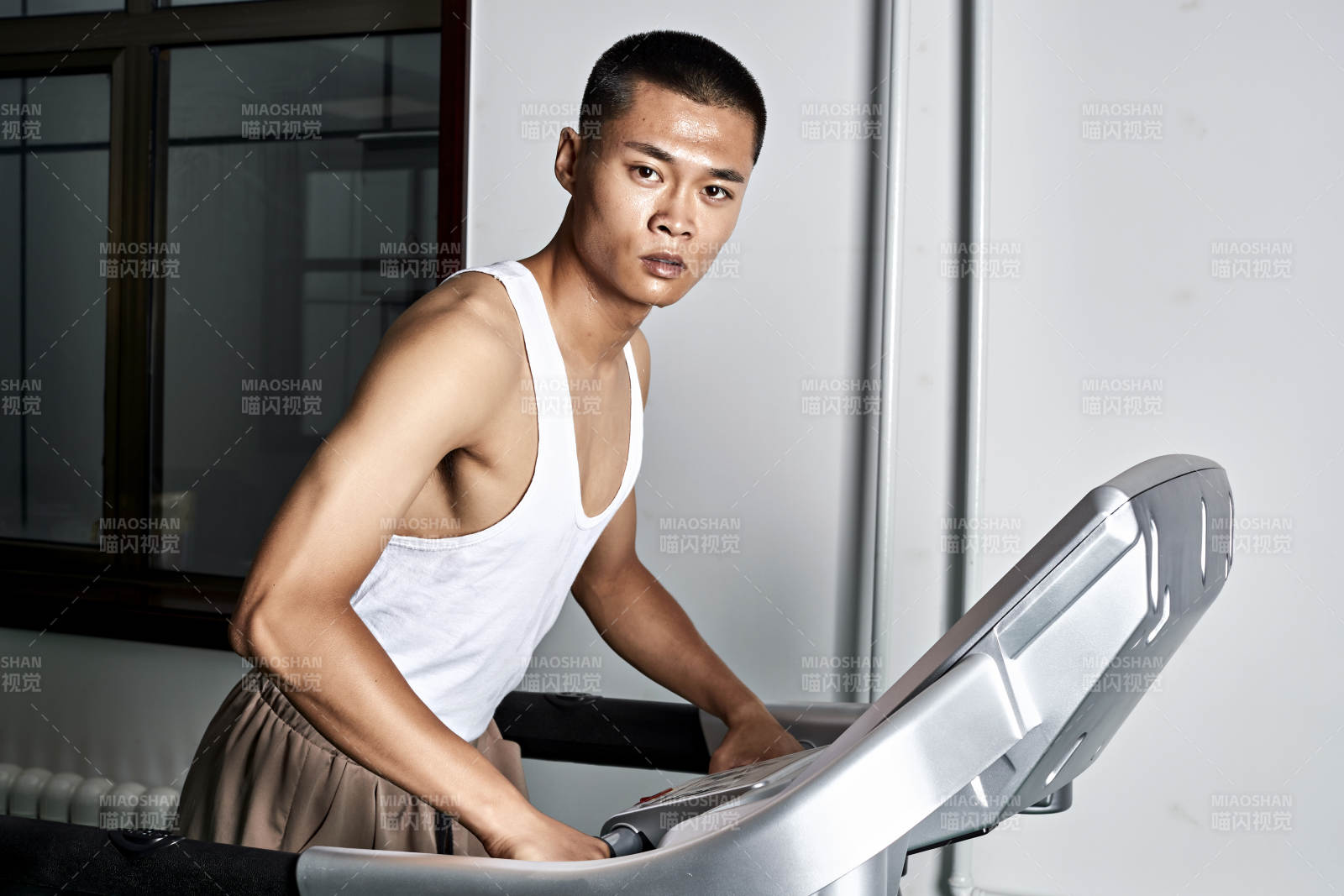 在室內用跑步機進行鍛煉的亞洲健身男士形象
