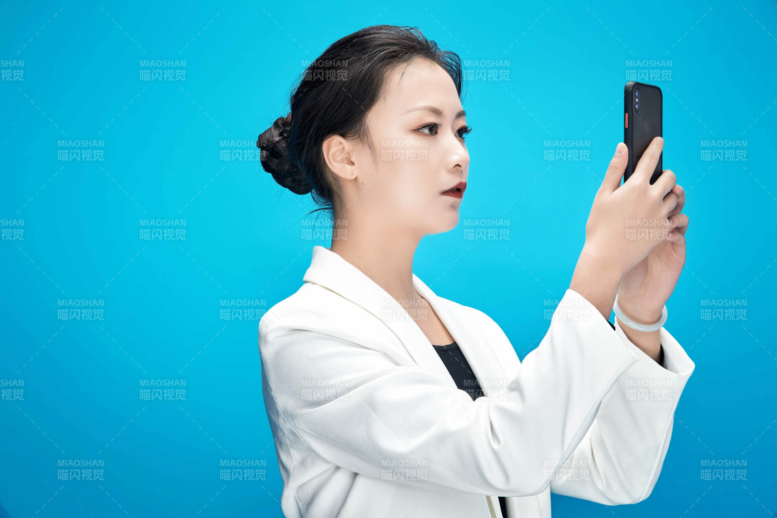 身穿西服拿著手機與文件夾的亞洲商務女士