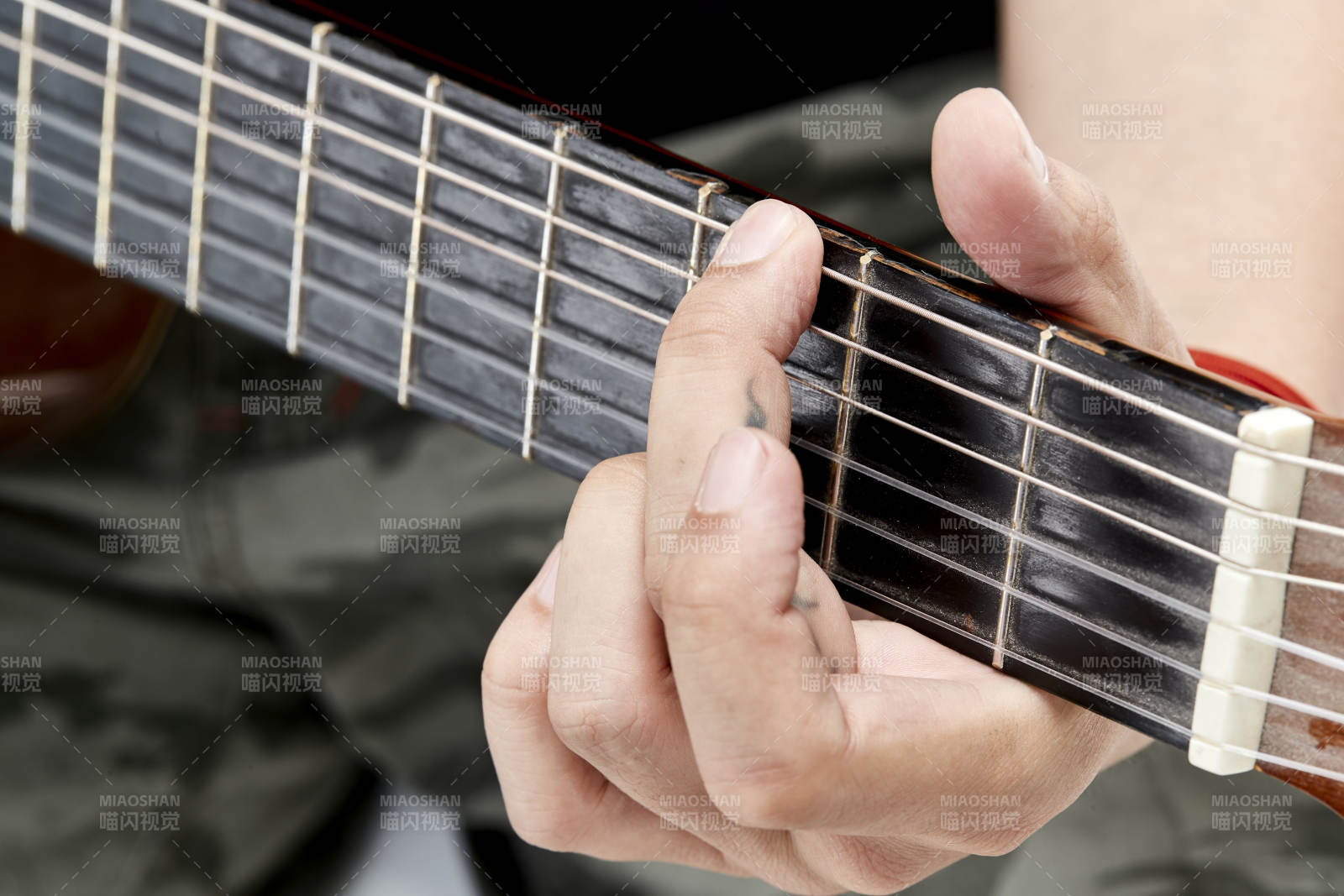 示范演奏古典吉他的亞洲男性樂手人像局部特寫