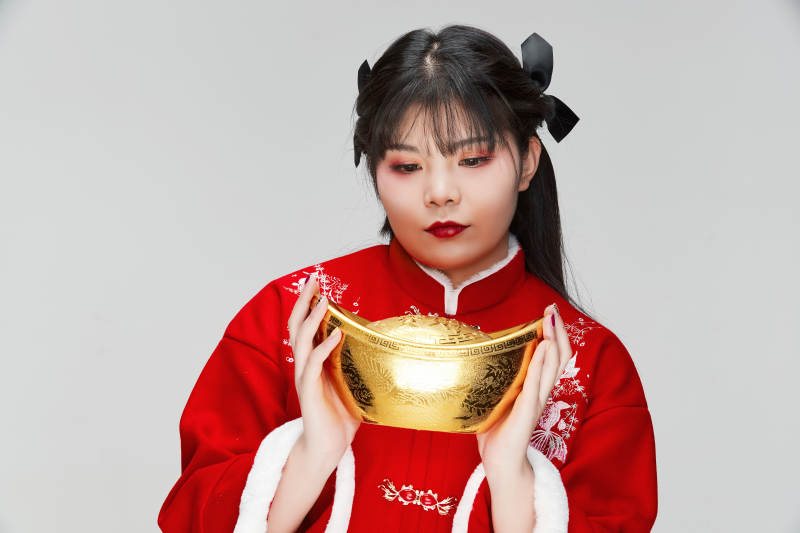 手捧金元宝身穿喜庆汉服的可爱少女