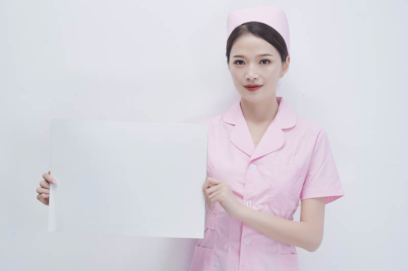 身穿粉色护士服佩戴听诊器的女性医护人员