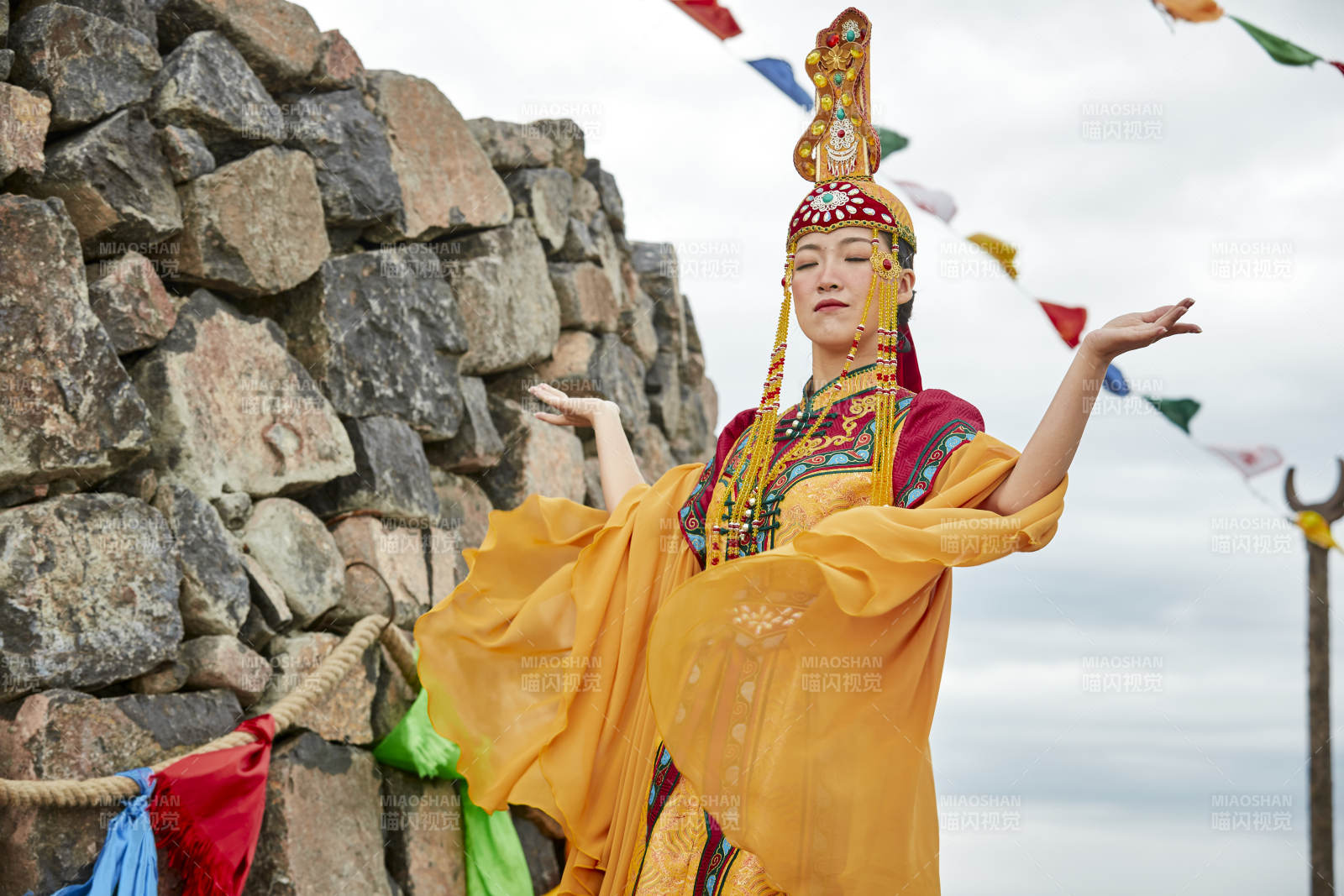 草原上敖包前身穿豪華蒙古族服飾的蒙族少女