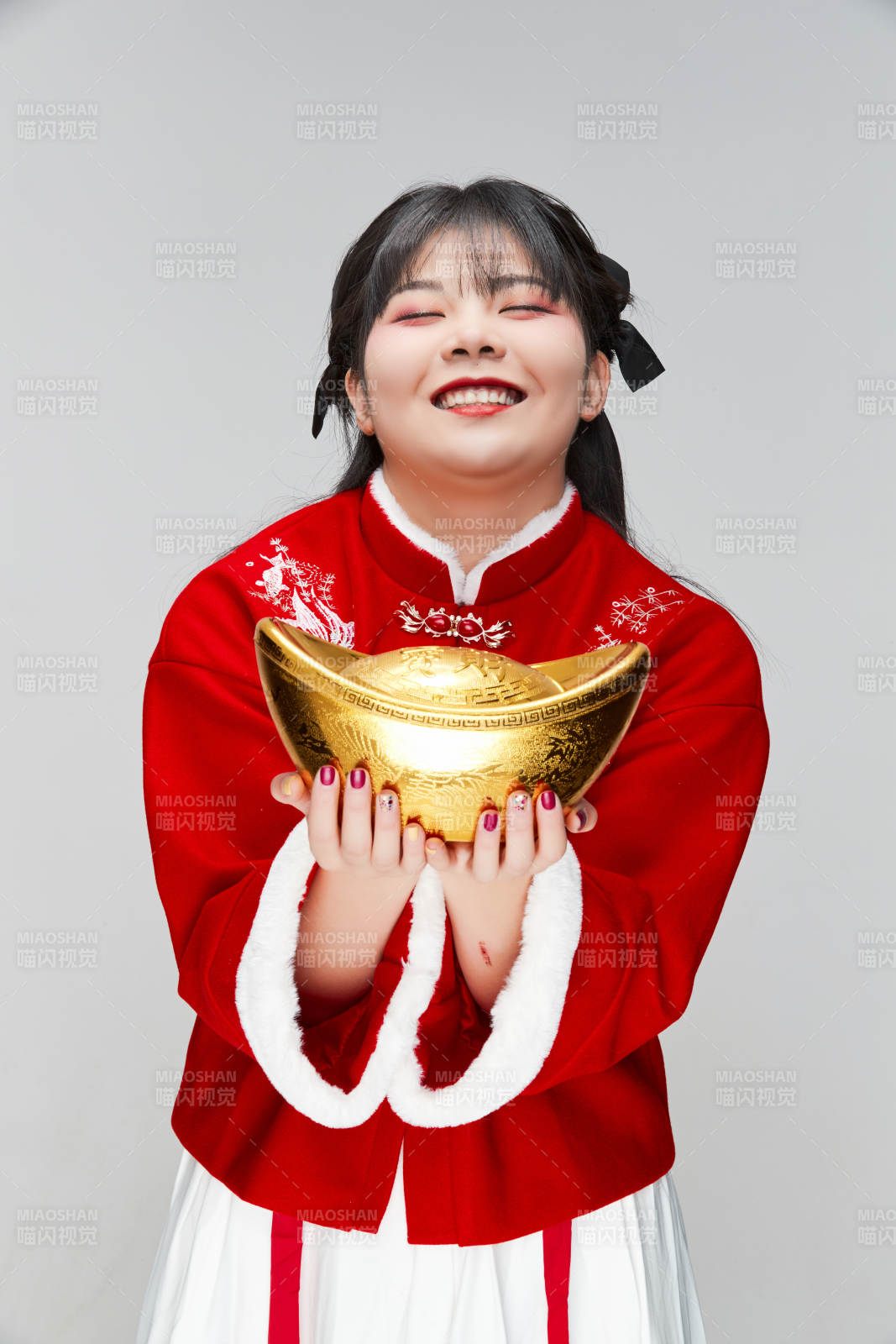 手捧金元寶身穿喜慶漢服的可愛少女