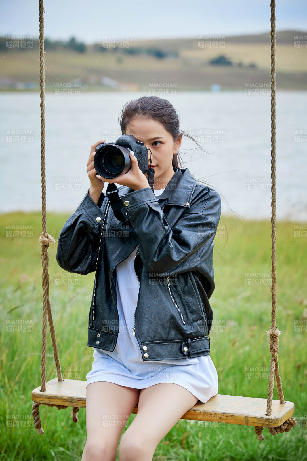 戶外湖畔進(jìn)行拍攝的亞洲青年女性攝影師