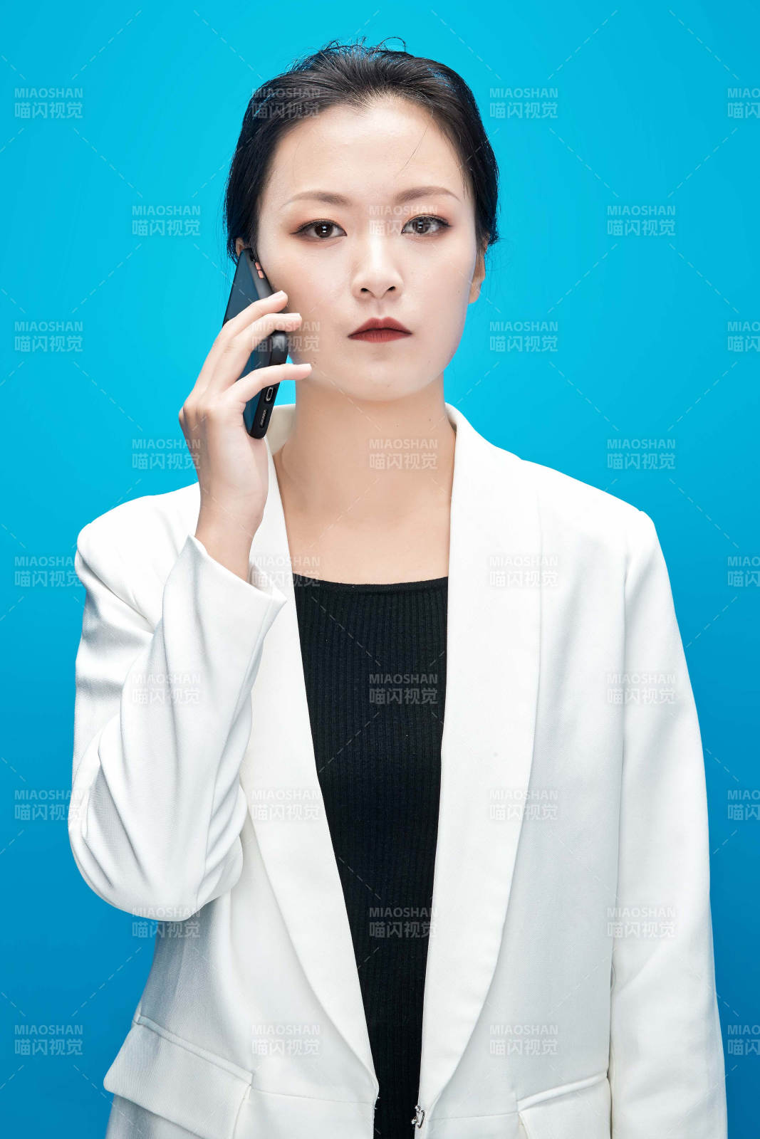 身穿西服拿著手機與文件夾的亞洲商務女士