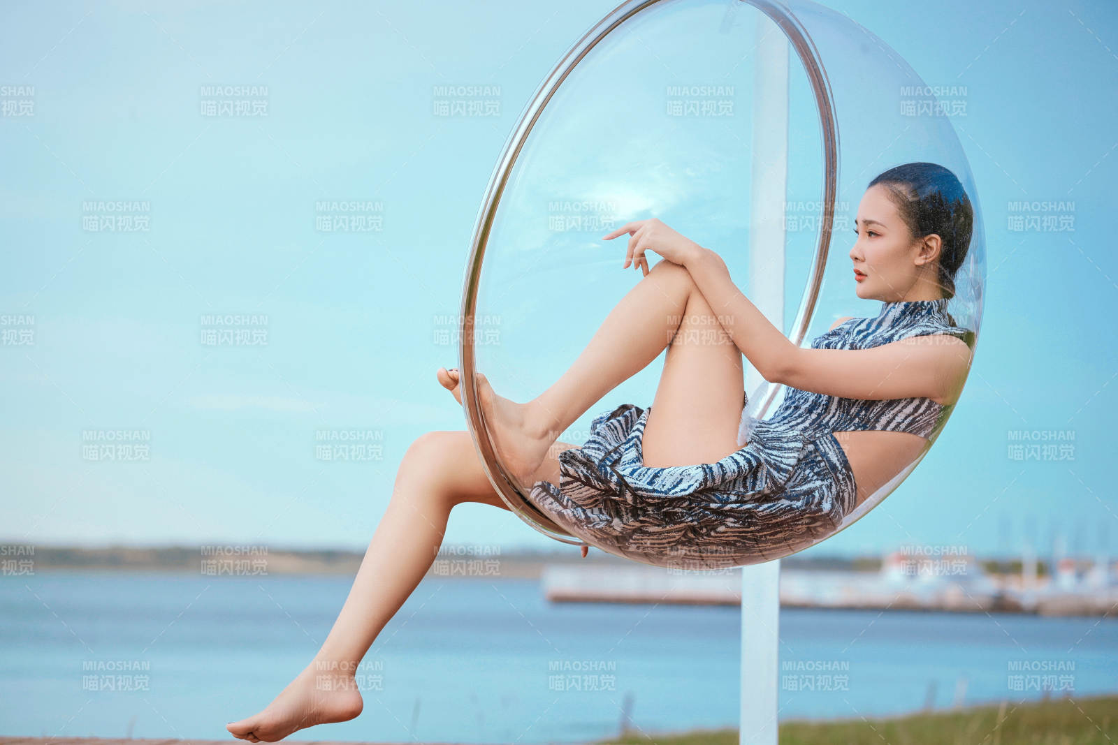 草原湖畔坐在透明秋千里的亞洲年輕女性人像