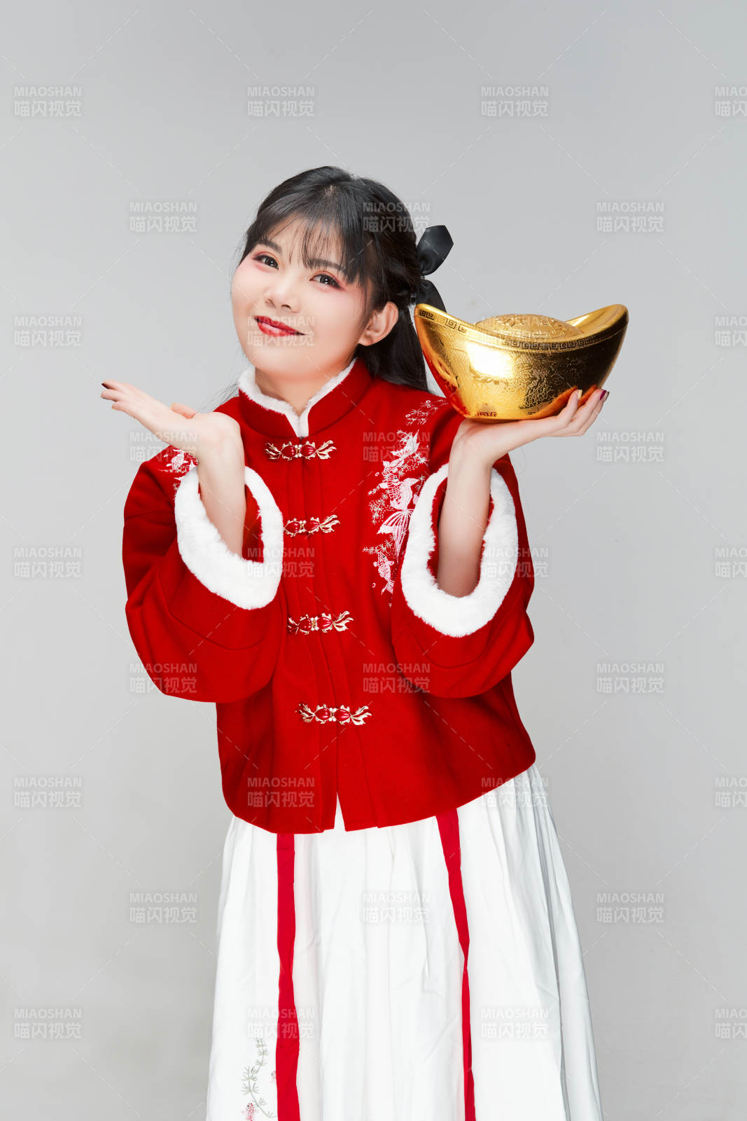 手捧金元寶身穿喜慶漢服的可愛少女
