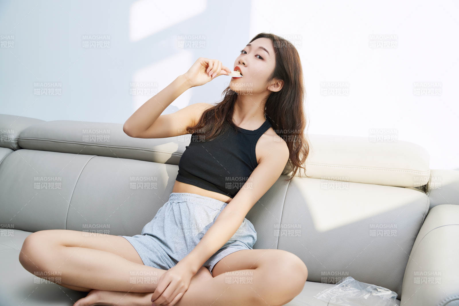 在家在沙發(fā)上享受美食的亞洲少女