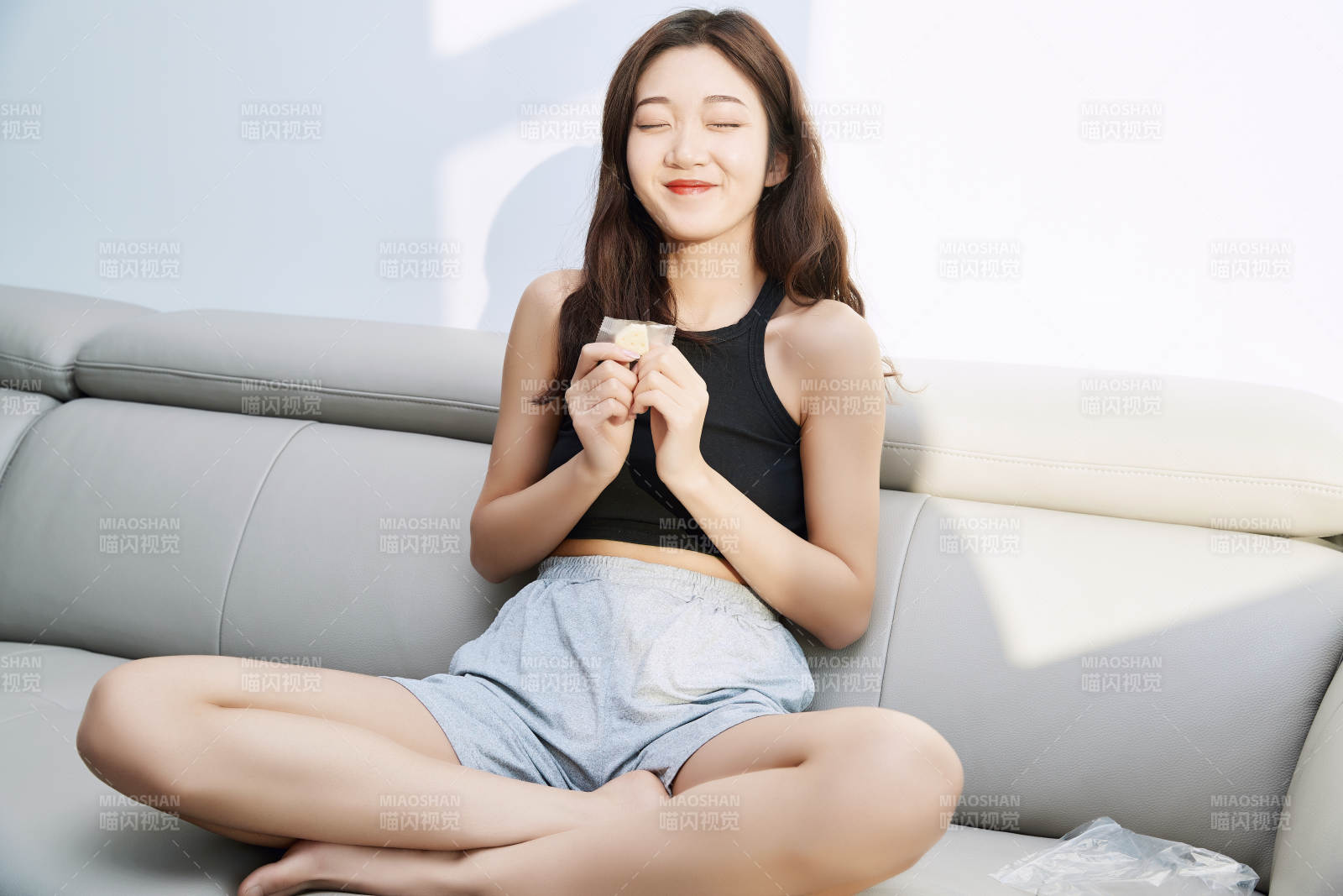 在家在沙發(fā)上享受美食的亞洲少女