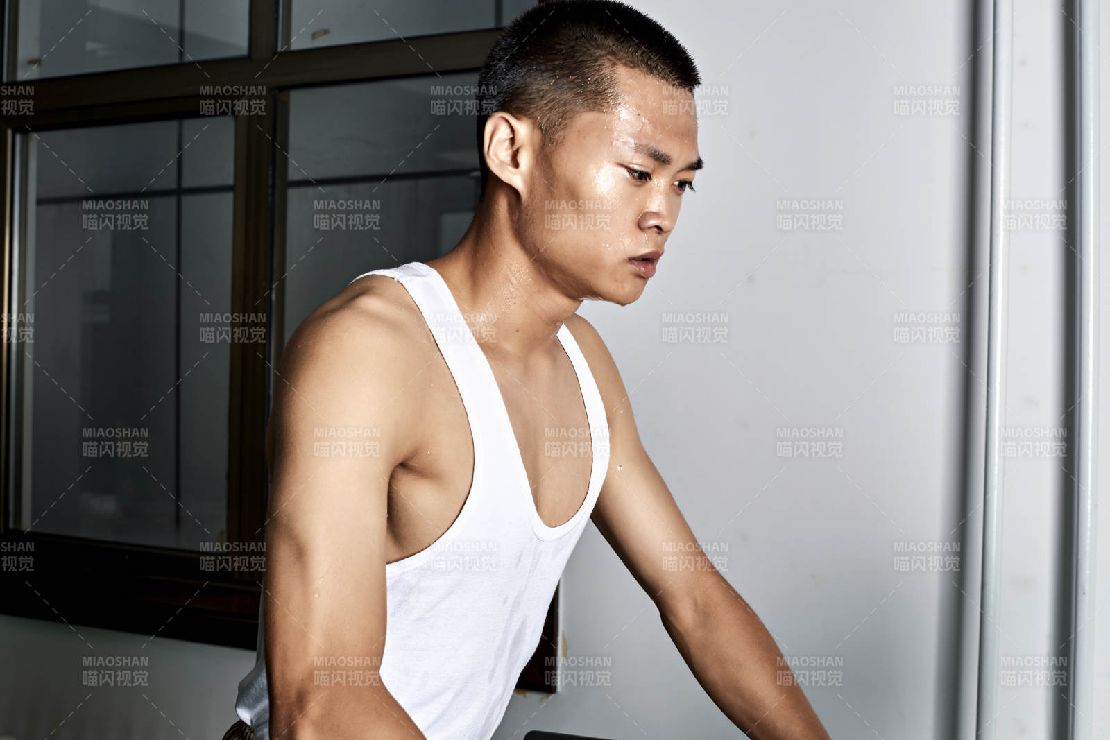 在室内用跑步机进行锻炼的亚洲健身男士形象