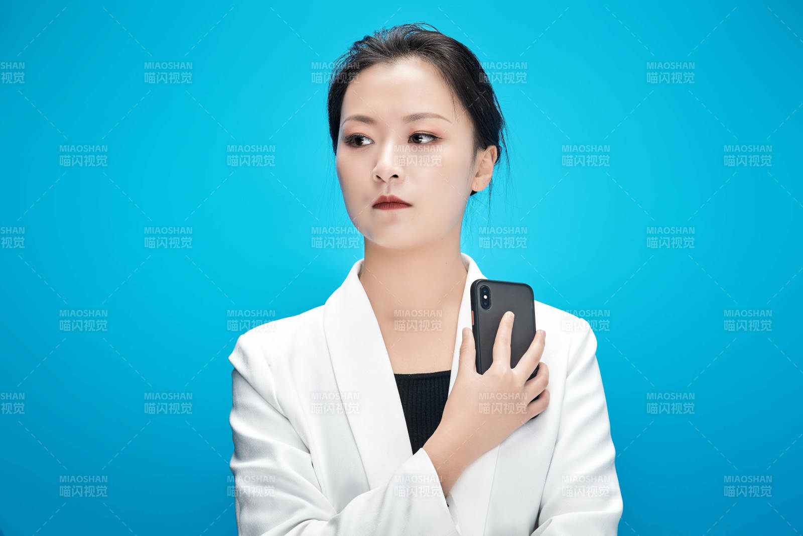 身穿西服拿着手机与文件夹的亚洲商务女士