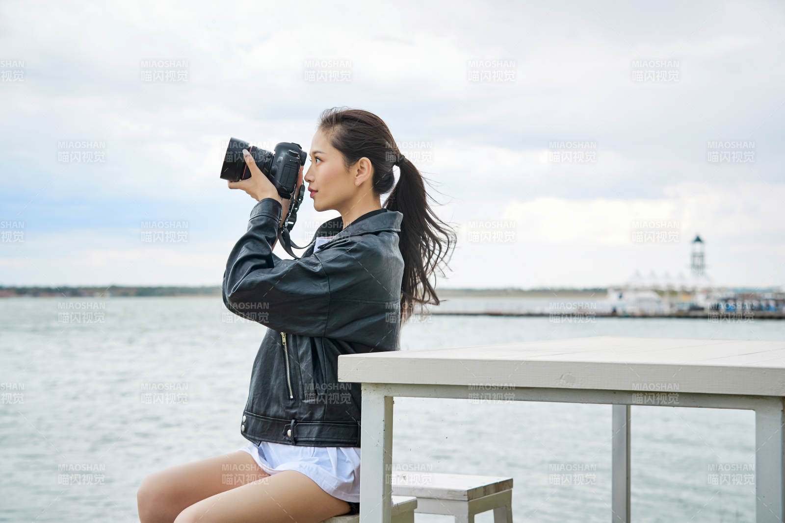 户外湖畔进行拍摄的亚洲青年女性摄影师