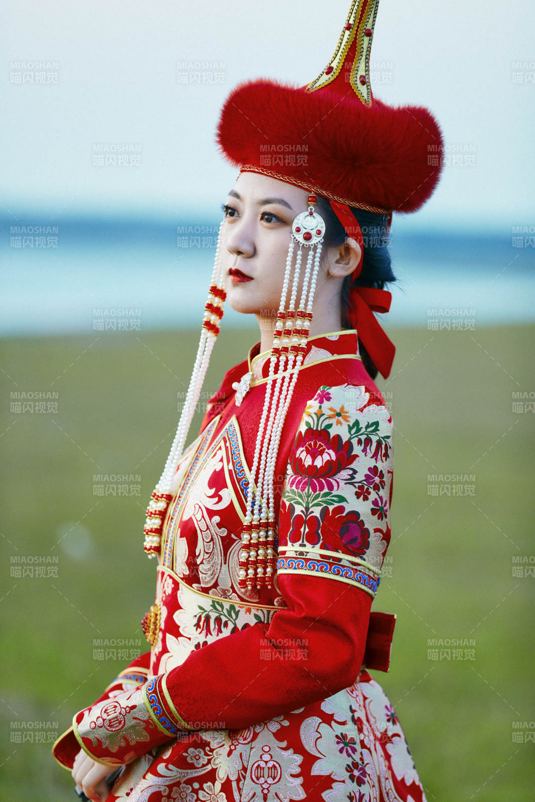 晚霞的草原湖畔穿蒙古族傳統(tǒng)服飾的年輕女性