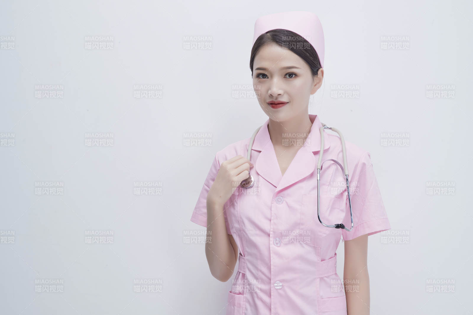 身穿粉色護士服佩戴聽診器的女性醫護人員