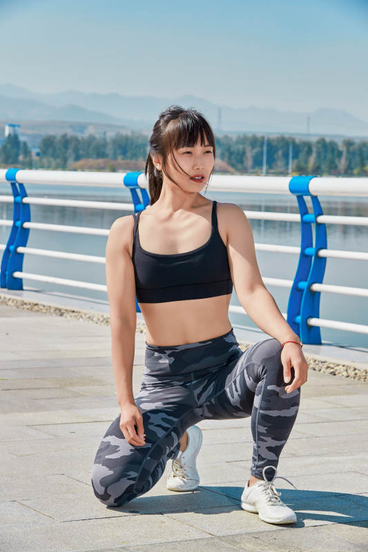 户外河畔公园做拉伸有氧运动的亚洲女性