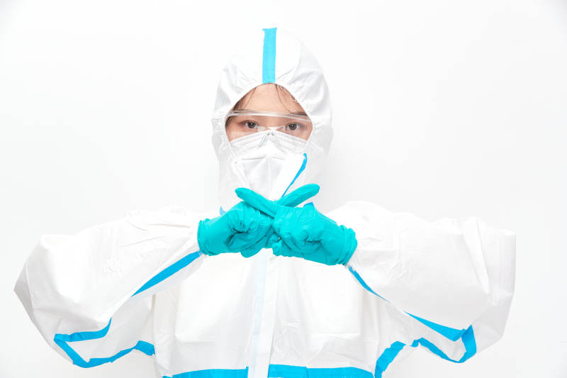 穿白色防护服佩戴护目镜口罩的女性医疗人员