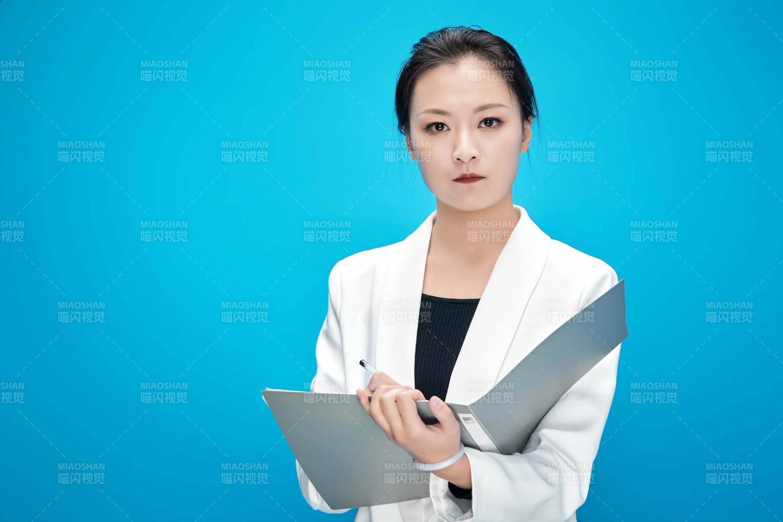 身穿西服拿著手機與文件夾的亞洲商務女士