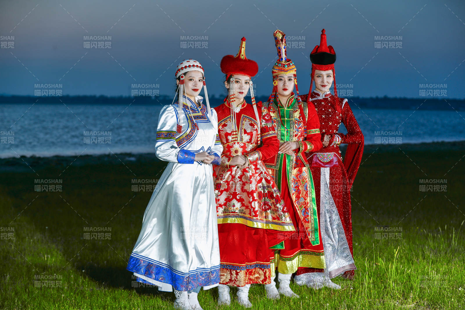 晚霞的草原湖畔穿蒙古族传统服饰的年轻女性图片