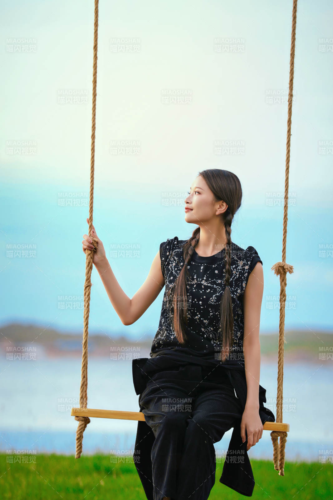 草原湖畔夕阳下荡秋千的亚洲少女